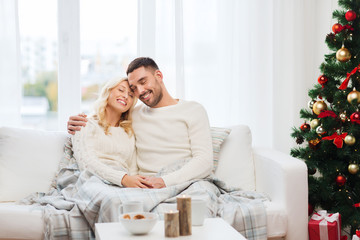 happy couple at home with christmas tree