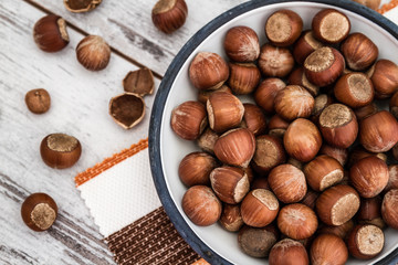 Hazelnuts in Enamel Bowl on White Wooden Table