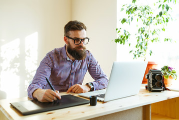 Artist drawing something on graphic tablet at the home office