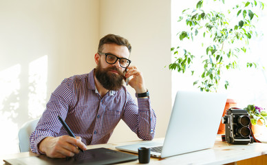 Artist drawing something on graphic tablet at the home office