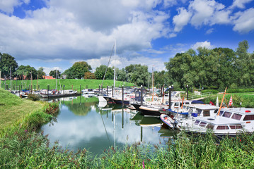 Obraz premium Tranquil harbor with yachts located in a green environment, Woudrichem, The Netherlands