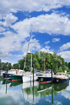 Moored yachts in a green harbor, Woudrichem, The Netherlands