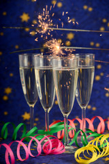 Glasses with champagne against holiday lights