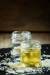 Sesame oil in the pot and sprinkled sesame seeds, selective focu