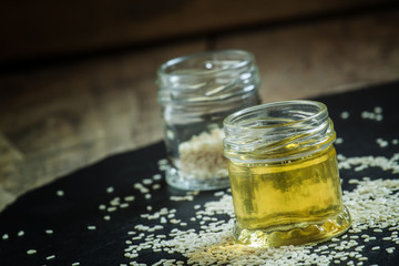 Sesame oil in the pot and sprinkled sesame seeds, selective focu