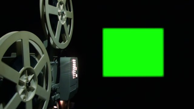 Close up of an old projector with a green screen.