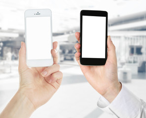 Hands holding black and white smart phones on light background