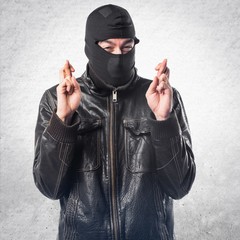 Robber with his fingers crossing