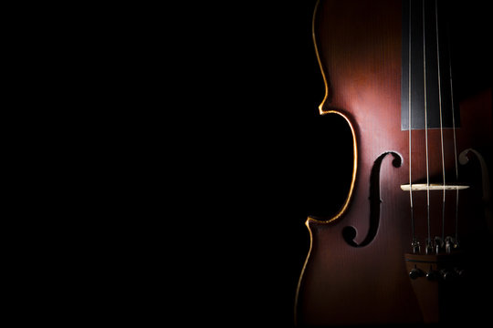 Old violin on black background.
