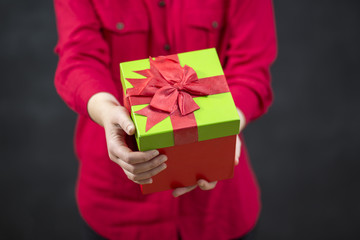 Happy smiling Santa girl with gift box enjoying falling snowflak