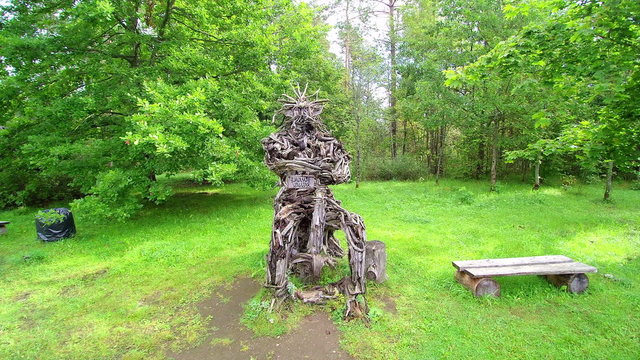 A sitting man statue made in sticks in the middle of the forest in Enumagi Estonia