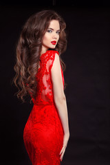 Beautiful sexy woman in red fashion dress isolated on black back