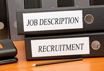Job Description and Recruitment binders on desk in the office