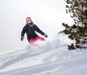 Fototapeta na wymiar Woman snowboarder in motion in mountains