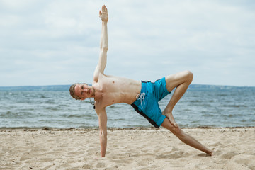 Fototapeta na wymiar Man doing yoga on the beach