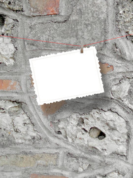 One hanged postcard with peg on ancient grey stone wall background