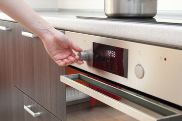 Close Up Of Women Hand Setting cooking mode on oven