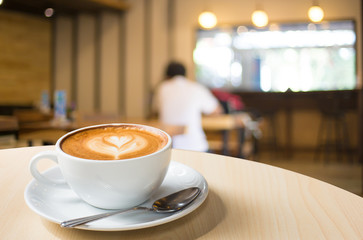 Selected focus empty brown wooden table and Coffee shop blur bac