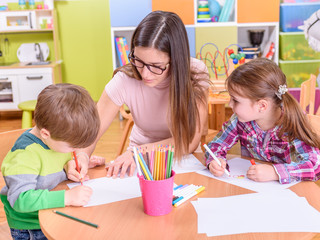 cute girl and boy with kindergarten teacher