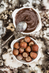 Chocolate Cream and Hazelnuts in White Bowls on Napkin