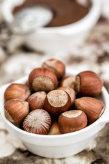 Chocolate Cream and Hazelnuts in White Bowls on Napkin