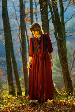 Woman in red dress portrait, autumnal forest