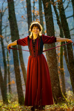 Woman in red dress portrait, autumnal forest