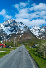 Asphalt road across norwegian village in sunny clear day