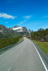 Asphalt road on Norvegian mountains in sunny clear day