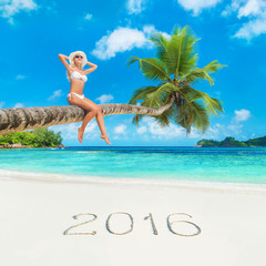 Cute woman at palm tree against tropical ocean beach, season 201