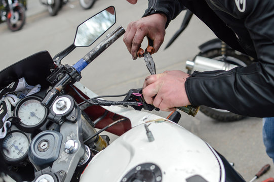 Close up picture of hands repairing motorbike