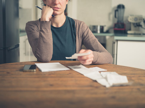 Woman looking at receipts at home