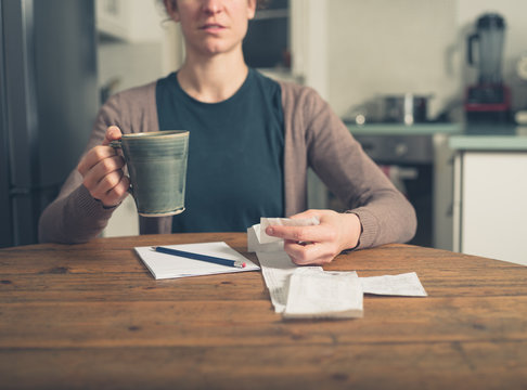 Woman looking at receipts and having tea