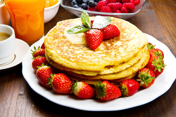 stack of freshly prepared traditional pancakes with strawberries