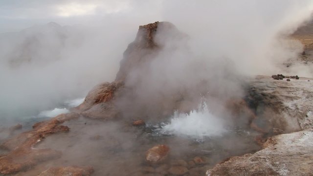 El Tatio geyser boils and produces steam at sunrise at the famous El Tatio geyser valley at 4320 meters above sea level,  Chile.