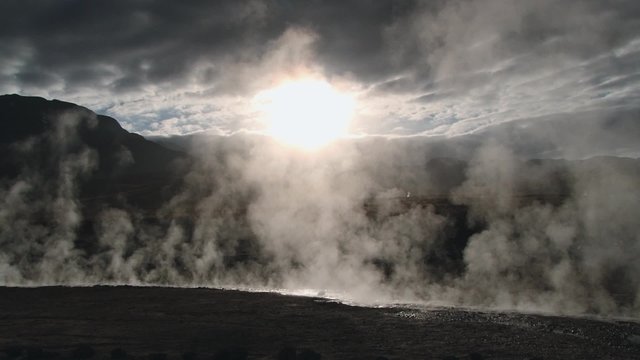 Spring with natural thermal water produces hot steam at sunrise at the famous El Tatio geyser valley at 4320 meters above sea level, Chile.