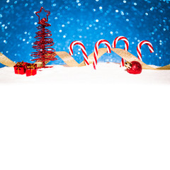 christmas red tree with candy in snow on blue glitter background