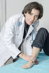 Female doctor touch the foot of patient.