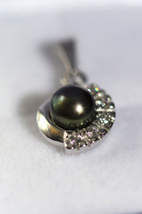 white gold pendant with black pearl and sapphire