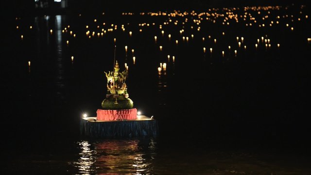 Burning candles float on water during Loi Khrathong celebration in Sukhothai, Thailand. 