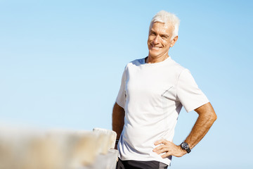 Naklejka na ściany i meble Man standing on beach in sports wear