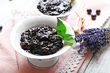 Fototapeta na wymiar Tasty currant jam with berries on table close up