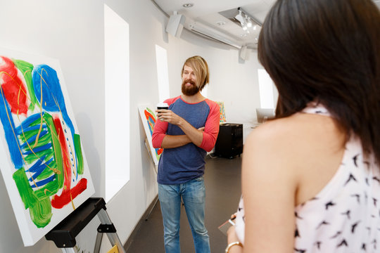 Young people standing in a gallery and contemplating artwork