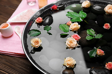 Spa composition of flowers and stones in water, close-up