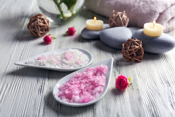 Composition of flowers, salt and stones on white wooden background, in spa salon
