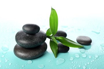 Hot spa stones with bamboo on light background