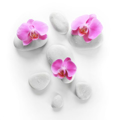 Obraz na płótnie Canvas White spa stones and orchids isolated on white
