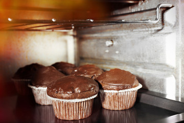 Chocolate cup-cakes in oven, close up