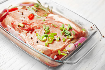 Marinating meat with spices on table, close up