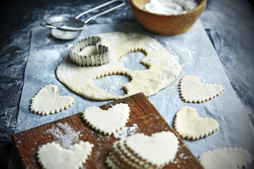 Uncooked heart shaped biscuits on a table